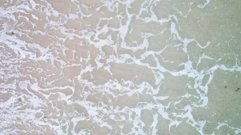 Top down view of sea waves and white foam on sand The Concept of nature and.. Stock Footage 336096832