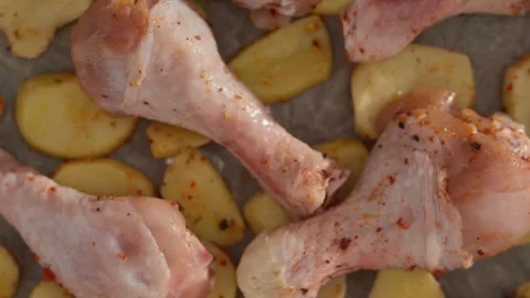 Top down view of seasoned raw chicken legs and potato slices Stock Footage 340516282