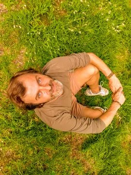 Top down view of a seated man looking up at the sky and towards the camera Stock Photos