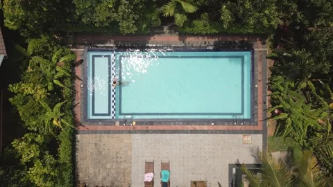 Top down view serene scene woman enjoying swim in private pool deep within .. Видео 309307533