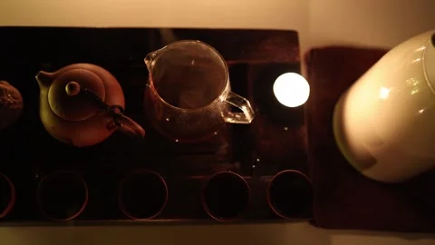 A top-down view of a serene tea setup featuring a Yixing clay teapot, a glass te Stock Footage 299385428