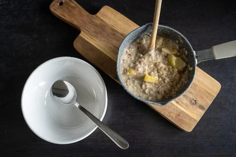 Top down view of serving oatmeal porridge with apple, cinnamon, raisins 写真素材