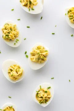 Top down view of several deviled eggs against a white background. 스톡 사진