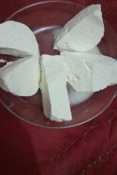 Top-down view of several thick, white, fresh cheese slices arranged 스톡 사진