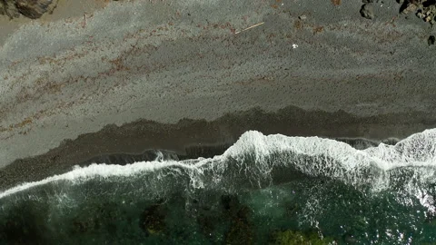Top down view of shoreline with waves and pebbled beach Stock Footage 300509604