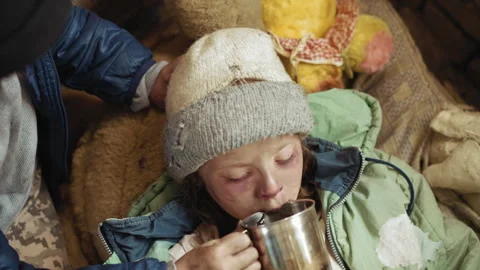 Top Down View of Sick Girl Drinking Water with Support in Harsh Conditions 動画素材 327020598