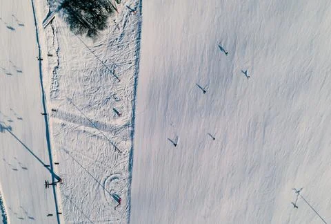 Top down view of a ski slope with skiers riding down the piste. Stock Photos
