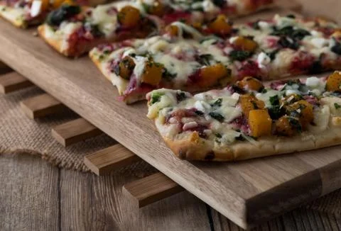 Top down view of slices of a squash and beet flat bread pizza ready for eating. Stock Photos