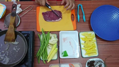 Top-down view of slicing crosshatch patterns into raw steak before cooking Stock Footage 345376743