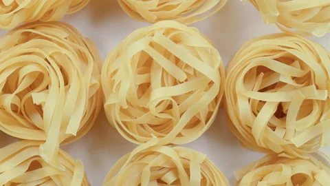 Top down view. Slider shot of a stack of uncooked Italian tagliatelle pasta. Stock Footage 296565877