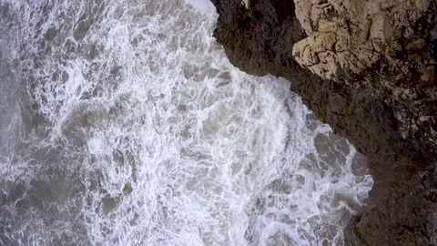 Top down view of slow motion waves crashing on a cliff of rocks. Rough dang.. Stock Footage 305067094