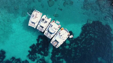 Top down view of small boats on crystal clear translucent blue water. Video stock 151511138