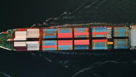 Top down view of a small container cargo ship leaving the harbor at speed Stock Footage 249753476