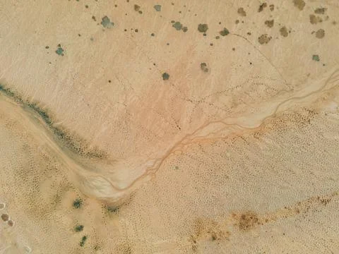 Top down view: small stream of water at the bottom of a dry lake. The unearthly Stock Photos