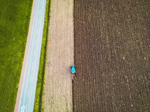 Top down view, small tractor ploughing a field of dirt Stock Photos