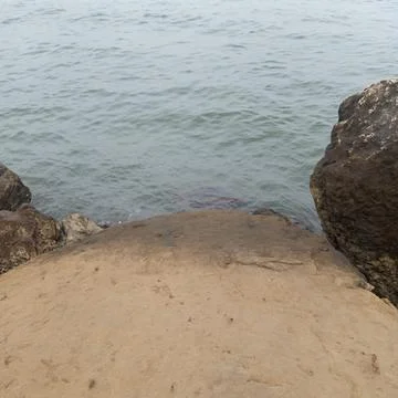 Top down view of smooth coastal rock with gentle ocean waves washing Stock Photos