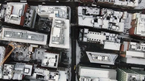 Top-down view of snow-covered city buildings and crossroad intersection in M Video stock 347969733