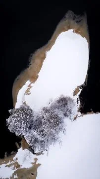 Top down view of snow covered island in open river Stock Photos