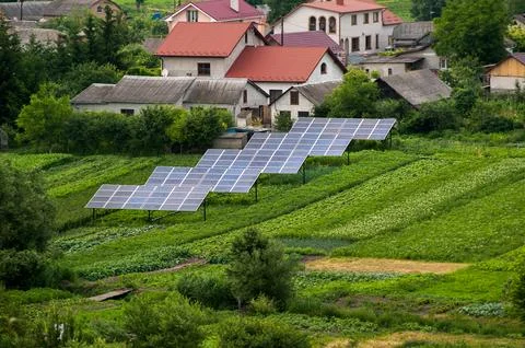 Top down view of solar panels in green country yard, vegetable garden and h.. Stock Photos