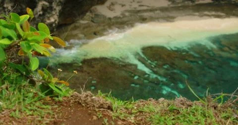 Top down view steep cliff overlooking sandy beach turquoise water rock bottom Video stock 341446381