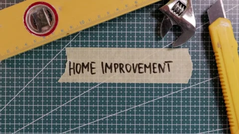 Top down view of sticking HOME IMPROVEMENT tape mockup with tools. Stock Footage 337816269