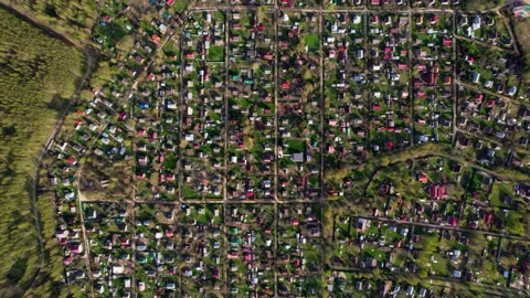 Top down view of suburbs around which green meadows. The village is divided by Stock Footage 229477009