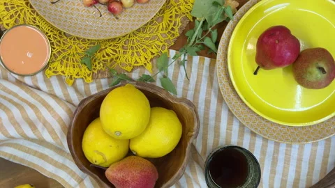 Top-down view of a summer table setting in progress. Bright yellow tableware and 動画素材 311846895