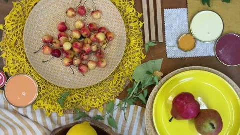 Top-down view of a summer table setting in progress. Bright yellow tableware and 動画素材 311847002