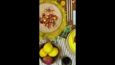 Top-down view of a summer table setting in progress. Bright yellow tableware and 動画素材 311847177