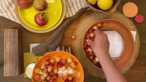 Top-down view of a summer table setting in progress. Bright yellow tableware and 動画素材 311856757
