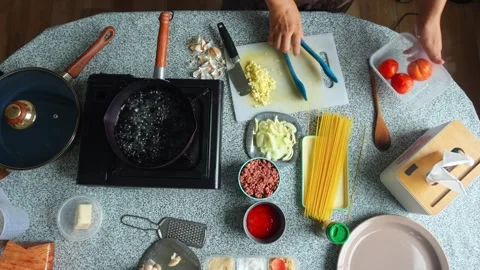 Top-down view of taking out blanched tomatoes and putting dry spaghetti into Stock Footage 345376701