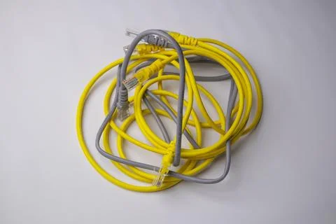 Top-down view of a tangled bundle of yellow and grey Ethernet patch cables,.. Stock Photos