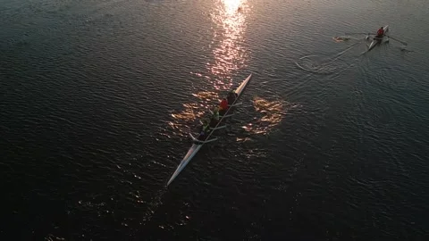 Top down view of a team of rowing athletes on blue water with a beautiful sunset Video stock 254373000