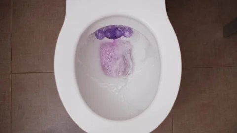 Top Down View of Toilet Flushing Paper with Purple Freshener Stock Footage 306839913