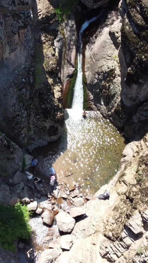 Top down view of tourists relaxing near wilderness waterfall pool in Kazakhstan Видео 338125073