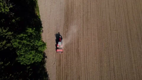 Top down view of a tractor with a seed drill sowing a field next to a forest Video stock 340514903
