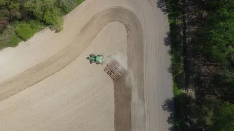Top down view of a tractor tilling a curved field Stock Photos