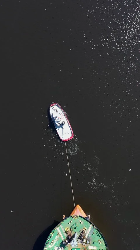 Top down view of a tugboat pulling a cargo ship in port of Varna, Bulgaria 스톡 동영상 306316410