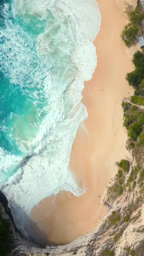 Top-down view of turquoise ocean waves crashing onto tropical remote beach Bali Stock Footage 310281591