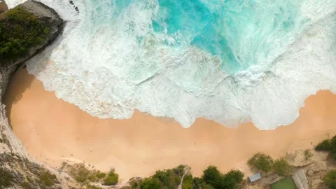 Top-down view of turquoise ocean waves crashing onto tropical remote beach Bali Stock Footage 310281613