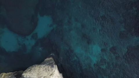 Top down view of the turquoise water next to the rocks aerial footage Stock Footage 101991147