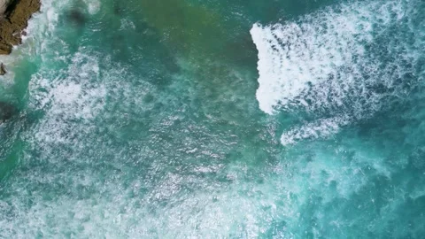 Top-Down View of Turquoise Waves Crashing on Rocky Shore Stock Footage 314987482