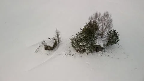 Top-down view of two abandoned wooden cabins in deep snow, winter landscape Stock Photos
