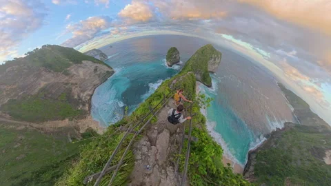 Top Down View of Two Tourists Walking Down Steep Cliff Path Toward Kelingking Be Stock Footage 337093048