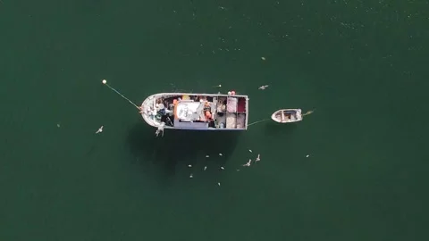 Top down view of two unidentifiable fishermen inside an old wooden fishing boat Stock Footage 247982981