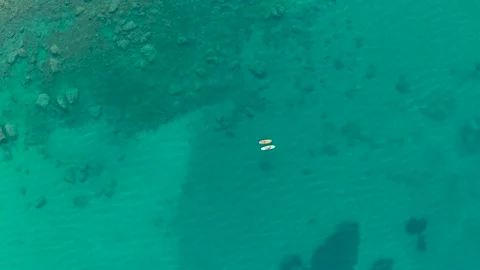 Top Down View of Two Women on Paddleboards in Clear Sea Stock Footage 337461978