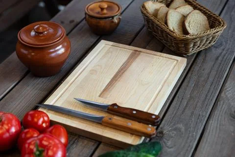 Top-down view, variety of fresh tomatoes and cucumbers next to a wooden cutti Stock Photos