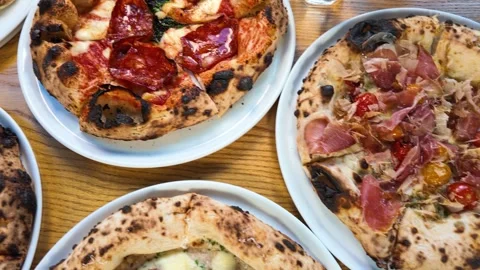 Top Down View of Various Gourmet Neapolitan Pizzas on Wood Table Stock Footage 339752169