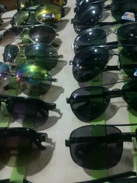 Top down view of various sport and polarized sunglasses on a market shelf Stock Photos