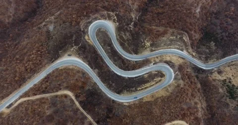 Top down view of a vehicle driving on a curved asphalt road Stock Footage 145990120